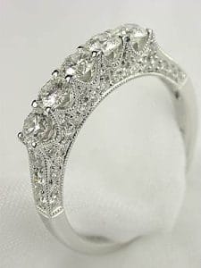 Our 5 stone diamond wedding ring captures the essence of this style with its delicate silhouette and a setting that evokes a sense of history.